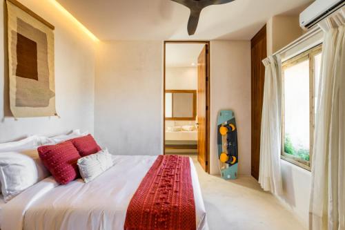 a bedroom with a large white bed with red pillows at Amina Wind Resort by Tasman in Salinas