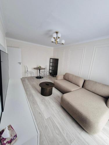 a living room with a couch and a table at Milan Luxury Apartaments IX#Maurer Residence -Targu Mures in Târgu-Mureş