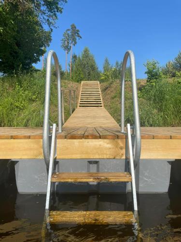 a wooden dock in the water with a ladder at MyHouse Silla Pärnu Holiday House in Silla