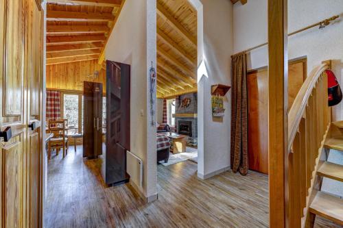 a living room with wooden ceilings and a staircase at Chalet Khione in La Tzoumaz