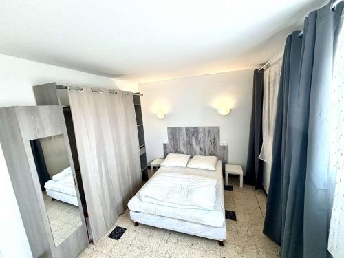 une petite chambre avec un lit et un miroir dans l'établissement Appartement 2 Pièces Port La Nouvelle PN540-012, à Port-la-Nouvelle
