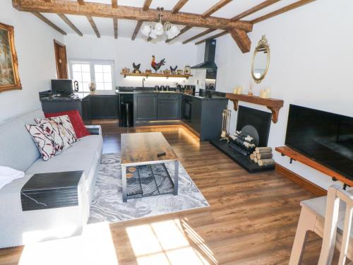 a living room with a couch and a fireplace at Rose Cottage in Nottingham