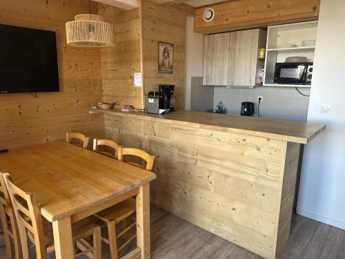 a kitchen with a wooden counter and a table with chairs at Résidence Ecrin d'Huez-2ch-7pers-Les Bergers-Alpe d'huez in LʼHuez
