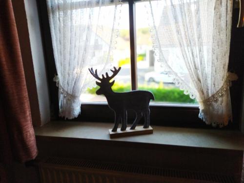 a statue of a deer sitting in a window at Wamperling - Erlebnisbrauerei mit wildem Wirtshaus und Pension in Neustadt bei Coburg