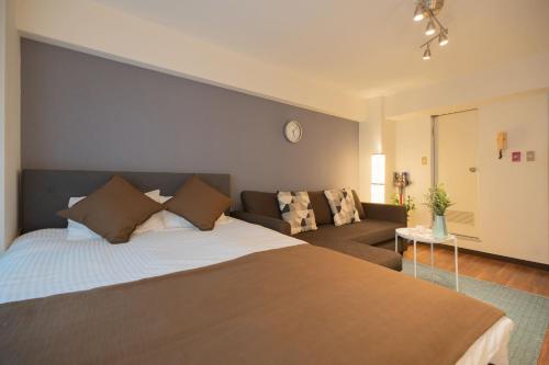 東京にあるNew Design Apartment in Shinjuku Kabukicho! 3 mins stationの大きなベッドとソファのある寝室
