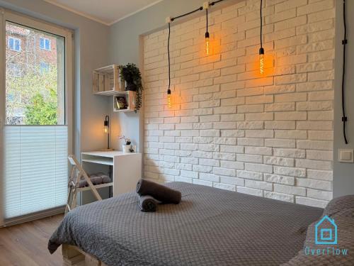 Un dormitorio con una pared de ladrillo y una cama. en Shrek Room 10 Min to Old Town Gdańsk,PKP & Shopping Mall, en Gdansk