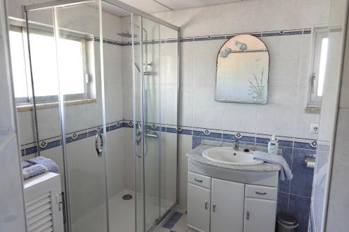 a bathroom with a glass shower and a sink at Aylevarroo Penthouse in Caniço