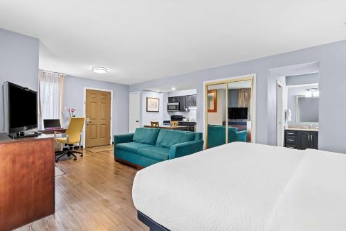 a hotel room with a bed and a living room at SureStay Studio by Best Western Pensacola in Pensacola