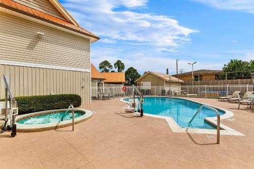 a swimming pool in front of a building at SureStay Studio by Best Western Pensacola in Pensacola