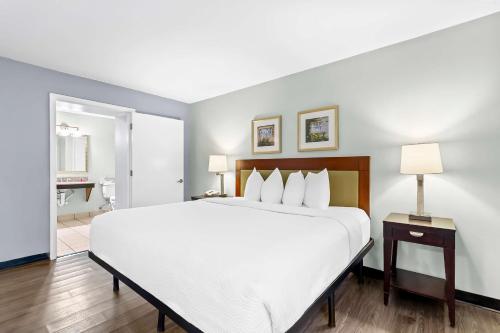 a large white bed in a hotel room at SureStay Studio by Best Western Pensacola in Pensacola
