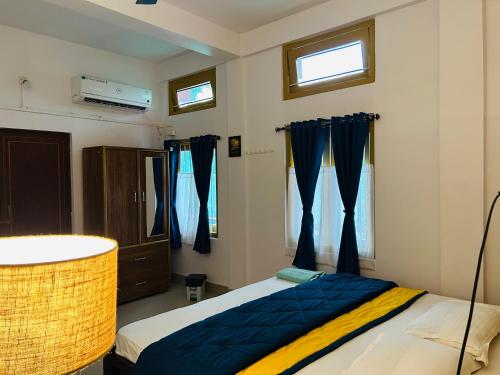 SibsāgarParag Abode - A Luxury Homestay的一间卧室配有蓝色和黄色窗帘的床
