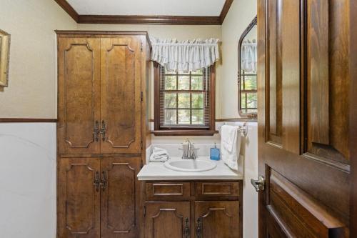a bathroom with a sink and a wooden door at Cajun Stays Cozy 3BR Ranch Near Lafayette with WiFi and Parking in Broussard