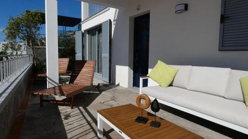 a white couch on the balcony of a house at Madeira Serenity Cottage in Funchal