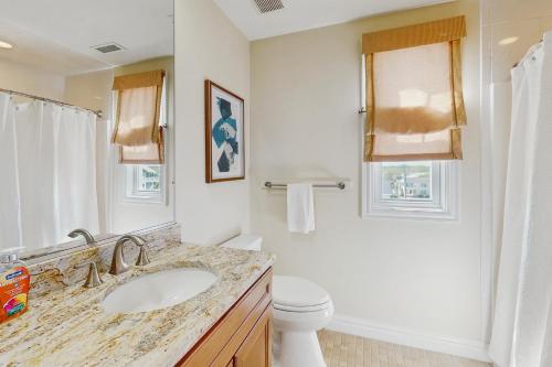 a white bathroom with a sink and a toilet at Dreamweaver in Virginia Beach