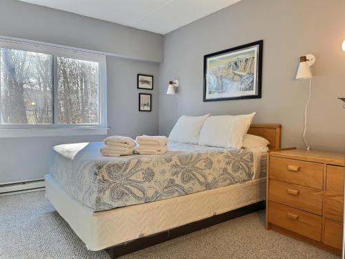 a bedroom with a bed with two towels on it at Moose Tracks Lodge - Pool, Hot Tub, Golf, Sauna in Killington