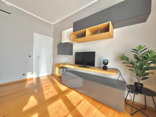 a living room with a desk with a tv on a wall at Attico Vista Lago, Relax & Wi-fi in Intra
