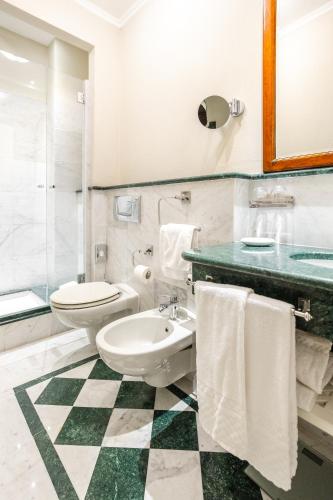 a bathroom with a toilet and a sink at Art Hotel Commercianti in Bologna