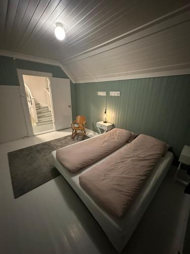 a bedroom with a large bed and a chair at Heggmoen Lodge in Bodø