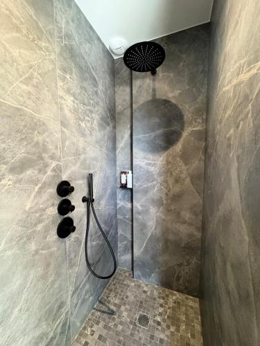 une douche avec pommeau de douche dans une salle de bain dans l'établissement Superbe Villa contemporaine avec piscine, Sainte Marine, à Combrit