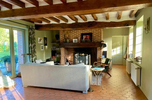 un salon avec un canapé et une cheminée dans l'établissement Beautiful Character House In The Heart Of Vexin, à Hardivillers-en-Vexin