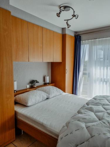 a bedroom with a large bed and a window at Sun & Sea Blutsyde in Bredene