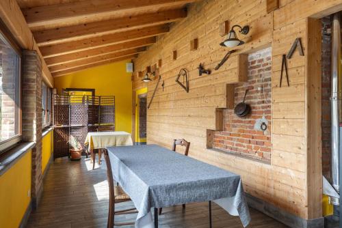 a dining room with a table and a brick wall at Fattoria Delle Vignole in Sommariva Perno