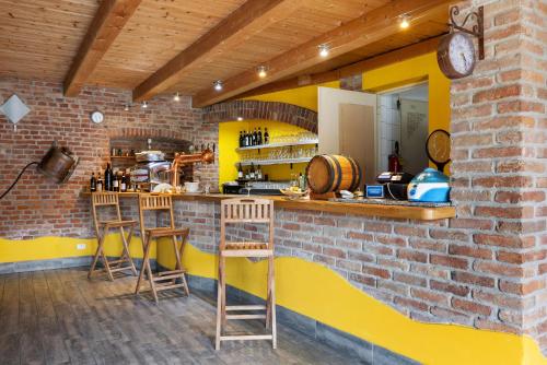 a kitchen with a brick wall and two bar stools at Fattoria Delle Vignole in Sommariva Perno