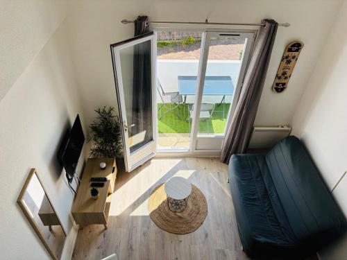 - une vue de tête sur un salon avec une porte coulissante en verre dans l'établissement Duplex cosy neuf - wifi - balcon - en bordure de forêt de pins - proche plage, à Saint-Jean-de-Monts