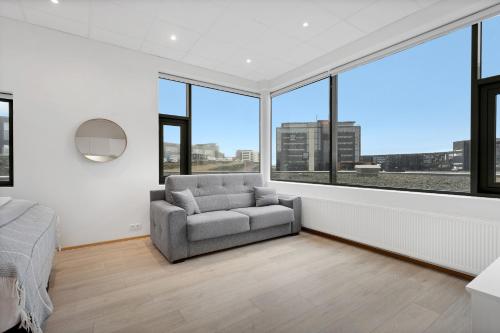 a living room with a couch and large windows at Blue Mountain Apartments by Heimaleiga in Reykjavík