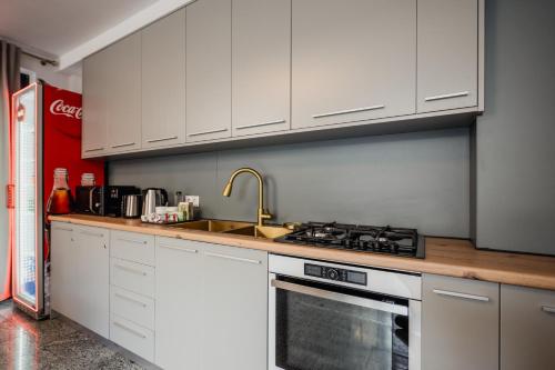 a kitchen with white cabinets and a sink and a stove at Aristide House in Bucharest