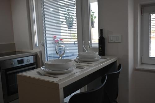 a kitchen counter with two dishes and a wine glass at Moda Studio Apartment in Ohrid
