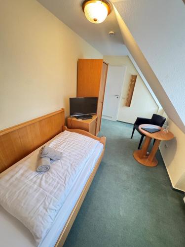 a bedroom with a bed and a desk and a chair at Hotel Müritzlicht in Waren