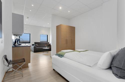 a bedroom with a white bed and a desk and a chair at Blue Mountain Apartments by Heimaleiga in Reykjavík