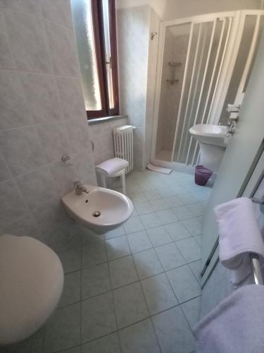 a white bathroom with a sink and a toilet at Acquacheta Valtancoli Hotel B&B in San Benedetto in Alpe