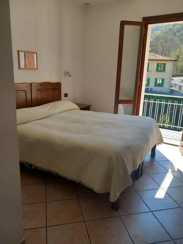 a bedroom with a bed and a large window at Acquacheta Valtancoli Hotel B&B in San Benedetto in Alpe