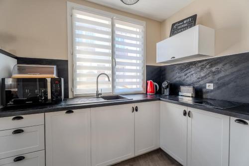 une cuisine avec des armoires blanches et un comptoir noir dans l'établissement 