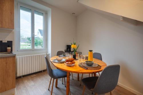 ラヴァルにあるLakaz - Maison - Jardin - Wifiの木製のテーブルと椅子のあるダイニングルーム