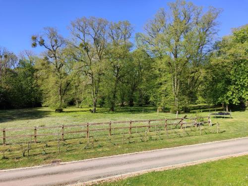 a fence on the side of a road next to a field at Chambres d'hôtes chez Sylvie in Donnemain-Saint-Mamès