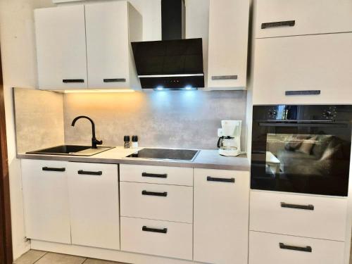 a white kitchen with a sink and a microwave at Titania 3 in Grömitz