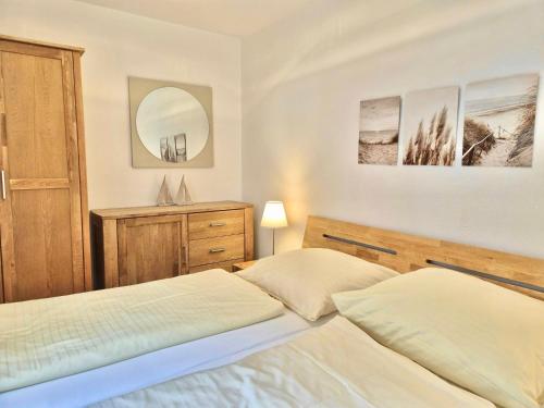 a bedroom with two beds and a mirror at Titania 3 in Grömitz