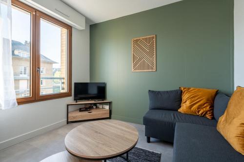 un salon avec un canapé et une table dans l'établissement Le Rivage - Wifi - Centre-ville, au Mans