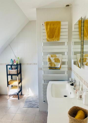 une salle de bain avec une baignoire blanche et un lavabo dans l'établissement Chez Armelle, à Savigné-lʼÉvêque