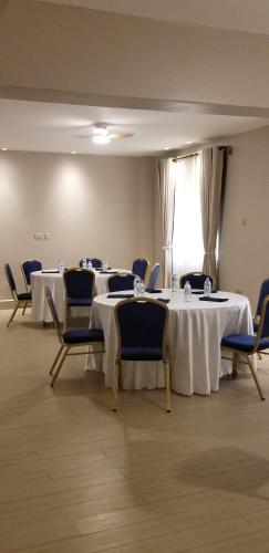 a conference room with two tables and chairs and a window at Blue Berries Hotel in Entebbe
