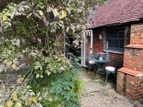 a brick house with a table and chairs in front of a window at Street Farmhouse in Godshill