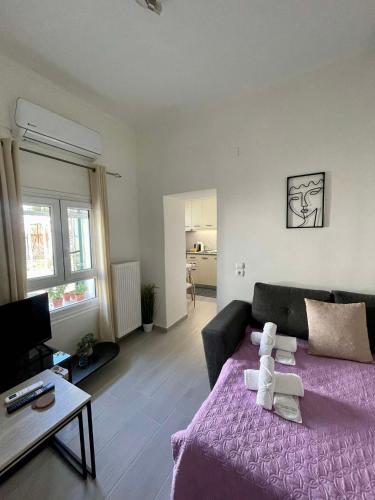 a living room with a purple bed and a couch at Helia Apartment 2 in Kanálion