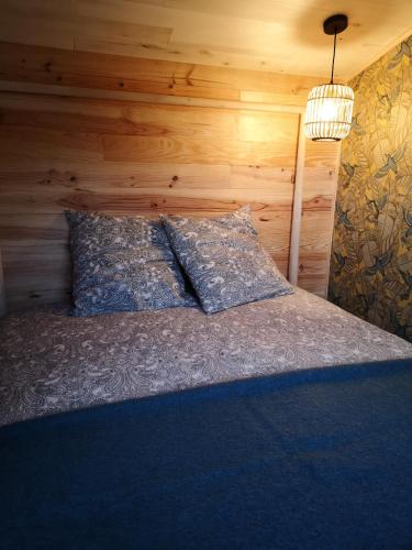 - une chambre avec un lit et un mur en bois dans l'établissement le Nid de la Monne, à Le Vernet-Sainte-Marguerite