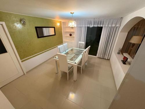 a dining room with a glass table and chairs at Casa Elegante-Sogamoso in Sogamoso