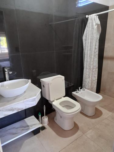 a bathroom with a white toilet and a sink at Alojamiento en catamarca in San Isidro