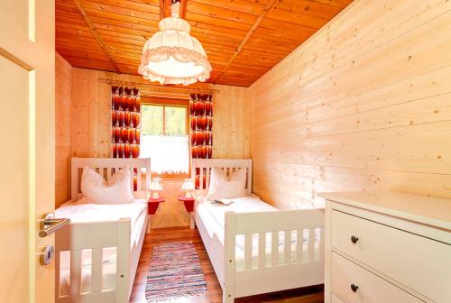 a bedroom with two beds and a chandelier at Ferienhaus Tribuser in Winkl Heiligenblut