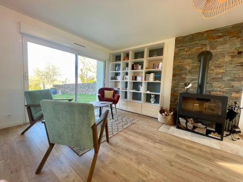 - un salon avec une cheminée, une table et des chaises dans l'établissement Ty Yan - wifi - nature, à Lanvéoc